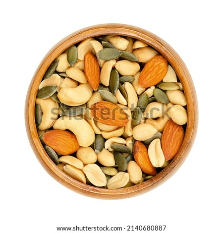 Nut-seed mix, in a wooden bowl. Unsalted and crunchy mix of roasted peanuts, cashews, pumpkin seeds and almonds. Close-up, from above, isolated on white background, macro food photo. Royalty-Free Stock Photo #2140680887