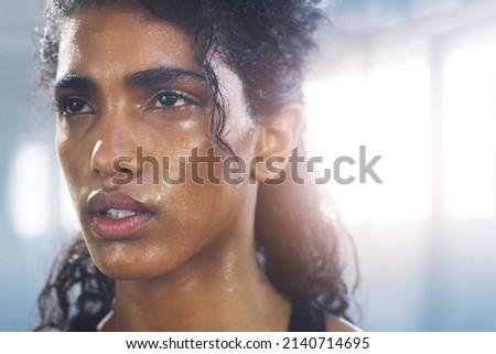 Cant shake me out of it. Close up shot of a focused and sweaty young sportswoman gathering her thoughts in the gym. Royalty-Free Stock Photo #2140714695