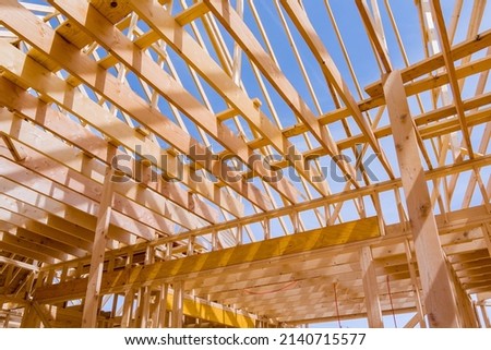 Wood roof trusses constructed with wooden construction framing beams timber Royalty-Free Stock Photo #2140715577