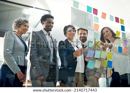Planning with purpose and positivity. Shot of a group of businesspeople brainstorming on a glass wall in an office. Royalty-Free Stock Photo #2140717443