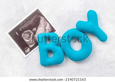 Ultrasound scan of unborn baby with letters boy