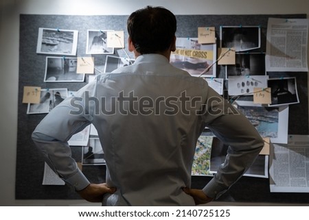 Policeman Or Private Detective Searching Crime Investigation Board Royalty-Free Stock Photo #2140725125