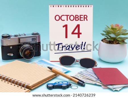 14th day of October. Travel planning, vacation trip - Calendar with the date 14 October glasses notepad pen camera cash passports. Autumn month, day of the year concept.