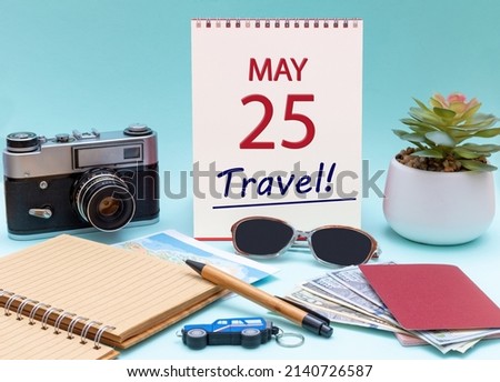 25th day of May. Travel planning, vacation trip - Calendar with the date 25 May glasses notepad pen camera cash passports. Spring month, day of the year concept.