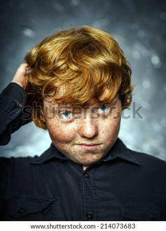 Fat freckled boy studio portrait in dark background