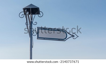 Vintage blank directional road signs against blue sky. White metal arrows on the signpost. Right pointing old direction sign with space for text.