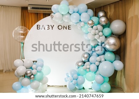 Arch decorated with blue, green, grey, and silver balloons. Baby one party. Trendy arch for 1 year. Reception at a birthday party.