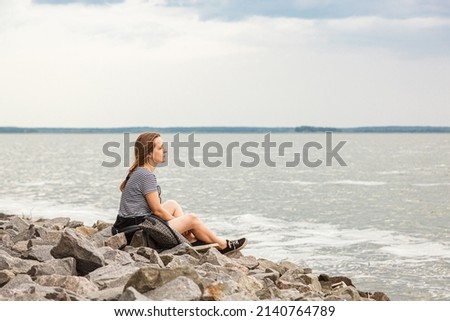 Beautiful girl on the sea with blue sky and clouds close up
