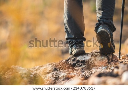 Close up mountaineering boots walking on rocky mountains at  outdoor. Tourist walks on adventure trip in natural at holidays. Travel lifestyle concept Royalty-Free Stock Photo #2140783517