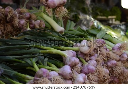 Close up of green and violet garlic on market stand