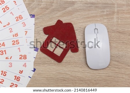 Paper Calendar with pc mouse and house figure on table. Housing rent