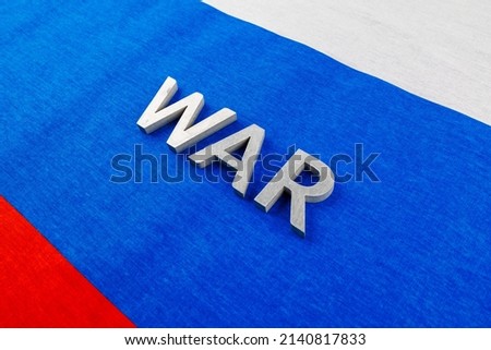 the word war laid with silver metal letters on Russian Federation tricolor flag - full-frame diagonal view