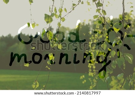 The inscription "Good morning" on a pastel green background of green trees, leaves and grass. Spring landscape, young birch leaves