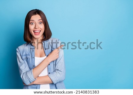 Photo of excited astonished person direct finger empty space offer proposition isolated on blue color background