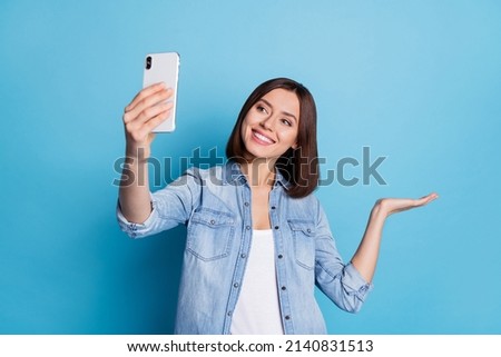 Photo of shiny cute lady dressed denim shirt tacking selfie gadget arm empty space isolated blue color background Royalty-Free Stock Photo #2140831513