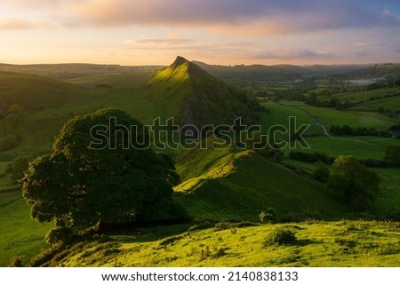Glorious sunrise with golden light at Chrome Hill in The Peak District, UK. Scenic views of green Summer British landscape.