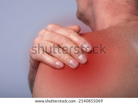 Shoulder pain close up. Abstarct man suffering from ache in body. Red point. High quality photo