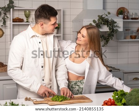Love couple cooking meal, cutting vegetables for salad together at home kitchen. High quality photo