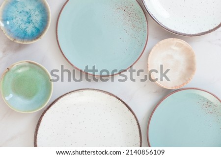 assorted ceramic plates on white marble table Royalty-Free Stock Photo #2140856109