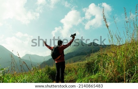 Travel photographer with awesome mountain view, Landscape photographer enjoying view at mountains, amazing nature view from Chembra Peak Wayanad, Kerala Travel and Tourism Image