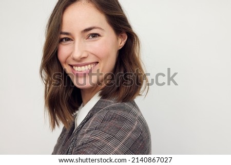 Portrait of beautiful young businesswoman looking happy and confident in camera. Big smile on her face, looking beautiful standing isolated on white background.