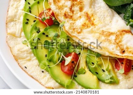 Healthy breakfast. Omelet with avocado, micro greens, tomatoes. Close up omelette