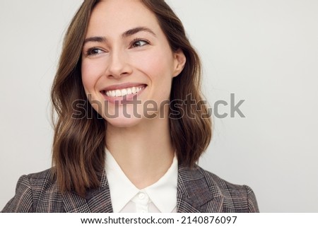 Close-up portrait of beautiful young businesswoman looking happy and confident to the left. Big smile on her face, looking beautiful and cheerful standing isolated on white background. Royalty-Free Stock Photo #2140876097