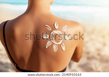 Sun Protection.Sun Cream. Woman Applying Sun Cream on Tanned  Shoulder In Form Of The Sun. Skin and Body Care. Girl Using Sunscreen to Skin.  Royalty-Free Stock Photo #2140910163