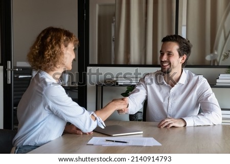 Happy employer hiring candidate after interview, congratulating on getting job, welcoming to team, shaking hand. Client thanking broker, lawyer for consultation with handshake after meeting Royalty-Free Stock Photo #2140914793