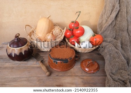 vegetable stocks are laid out on wooden shelf, ripe red tomatoes, head of cabbage in basket, garlic, pumpkin, onions, old dishes, concept of ingredients for cooking homemade food, vitamin products