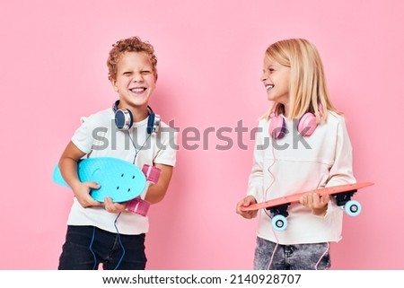 boy and girl stand next to skateboards isolated background