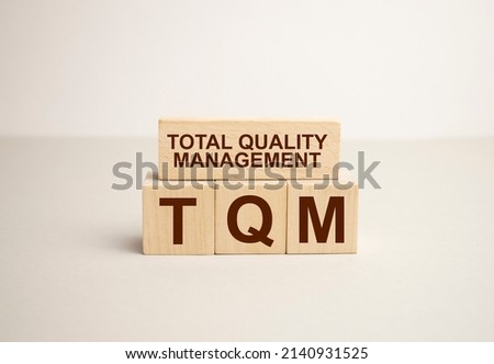 TQM, TEXT on wood cubes on a light background Royalty-Free Stock Photo #2140931525