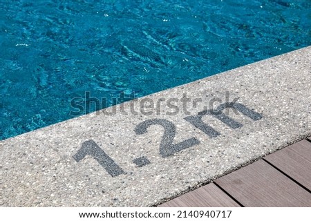 Pool depth warning sign on swimming poll side. Showing swimming pool depth of 1.2 meter. Royalty-Free Stock Photo #2140940717