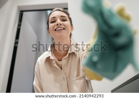 Close up picture of a smiling woman in yellow gloves