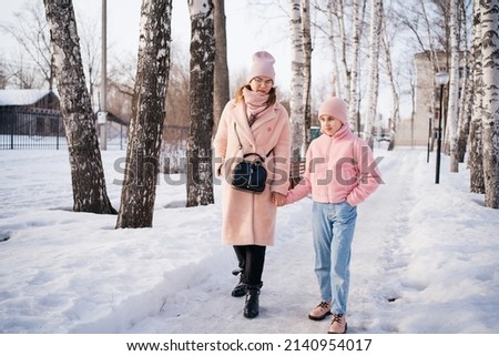 cheerful spring walk in the park mom and daughter on a sunny day. High quality photo