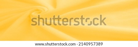 Yellow Cotton. abstract background of luxury fabric or liquid silk texture of waves or wavy folds. background or elegant wallpaper design. Cotton texture, natural fabric and dye, bright yellow color