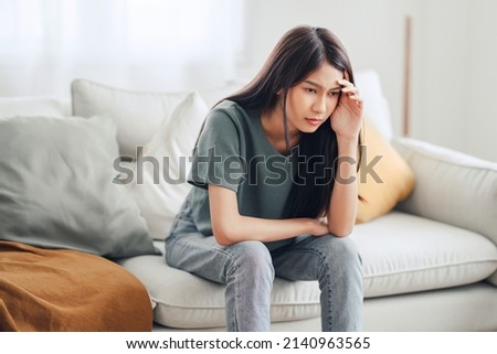 Sad tired young asian woman touching forehead having headache migraine or depression, upset frustrated girl troubled with problem feel stressed, Grief sorrow concept Royalty-Free Stock Photo #2140963565