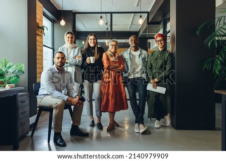 Group of diverse businesspeople smiling at the camera in a creative office. Team of multicultural entrepreneurs running a successful startup in an inclusive workplace. Royalty-Free Stock Photo #2140979909