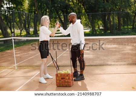 Black man talking with woman at tennis court