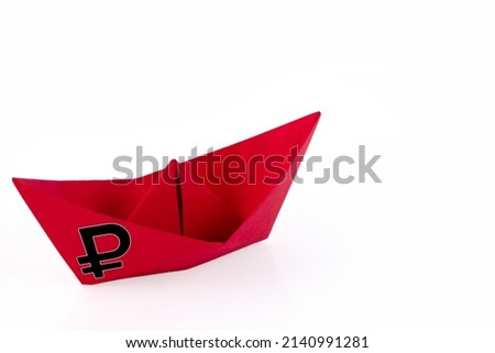 Red paper boat with the symbol of the Russian ruble on a white background. The concept of a Russian warship is going to the bottom. High quality photo