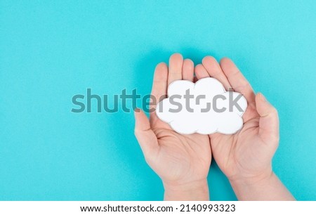 Holding a white cloud in the hand, empty copy space for text, blue background, communication and marketing concept, being connected, networking