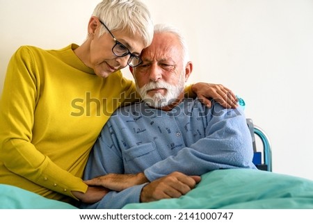 Senior woman with seriously ill husband in hospital. Healthcare support anxiety love concept Royalty-Free Stock Photo #2141000747
