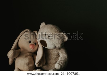 Stuffed toys brown teddy bear hugs bunny. Psychological help for children concept.