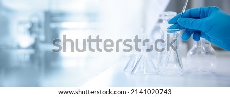 hand of scientist with test tube and flask in medical chemistry lab banner background Royalty-Free Stock Photo #2141020743