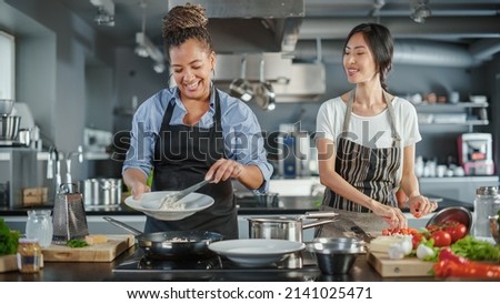 TV Cooking Show Kitchen with Two Master Chefs. Asian and Black Female Hosts Talk. Professionals Teach How to Cook Food, Taste Delicious Dish. Online Video Class Courses. Healthy Dish Recipe Prepare Royalty-Free Stock Photo #2141025471