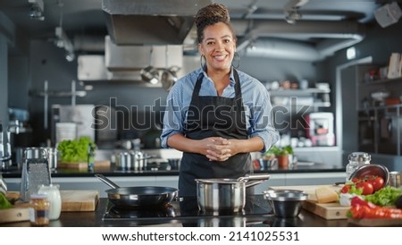 TV Cooking Show in Restaurant Kitchen: Portrait of Black Female Chef Talks, Teaches How to Cook Food. Online Courses, Streaming Service, Learning Video Lectures. Healthy Dish Recipe Preparation Royalty-Free Stock Photo #2141025531