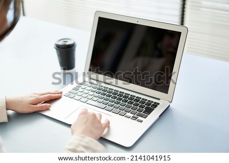 Asian woman operating a laptop
