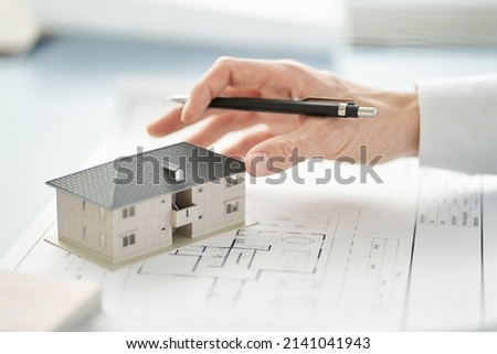 Asian architect writing on building drawings Royalty-Free Stock Photo #2141041943