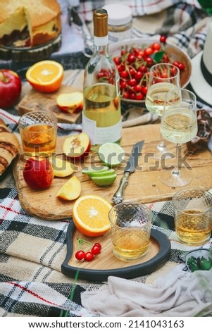 Summer picnic in nature. Toned picture. Fruits, wine, sandwiches and flowers
