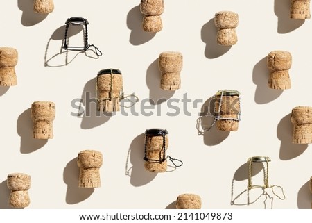 Creative pattern with champagne cork on beige background with hard light and shadows at sunlight. Minimal summer layout with bottle cap from sparkling wine and metal wire muselet, top view, flat lay Royalty-Free Stock Photo #2141049873